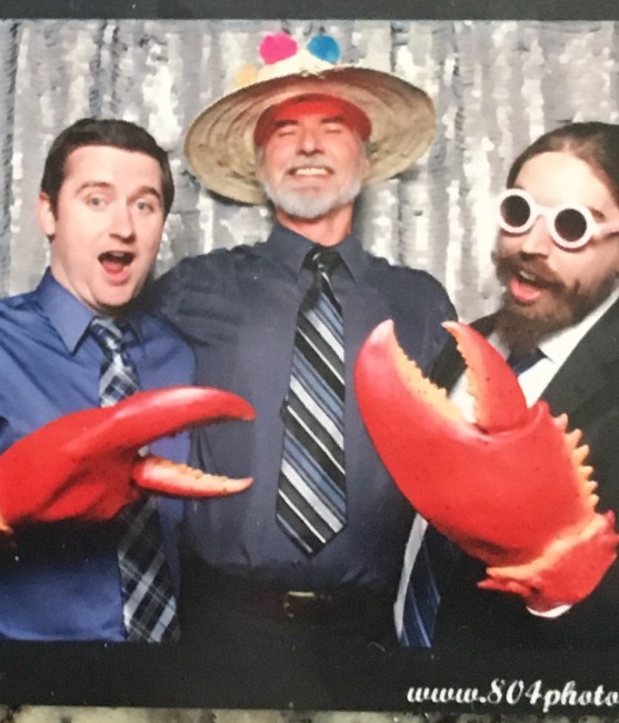 Matt, Amy's Dad, and Amy's brother being silly in a photo booth.