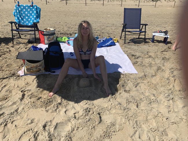Amy building a sand castle with no tools except her hands.