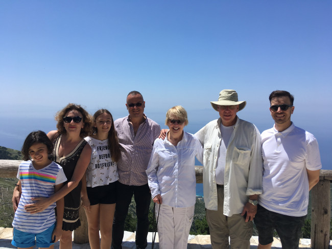 Stephen's parents visit Sela's family in Europe - at a mountain overlook with the sea below.