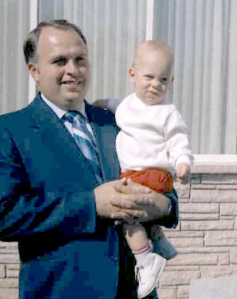 A father holds his adopted 8-month-old son.  