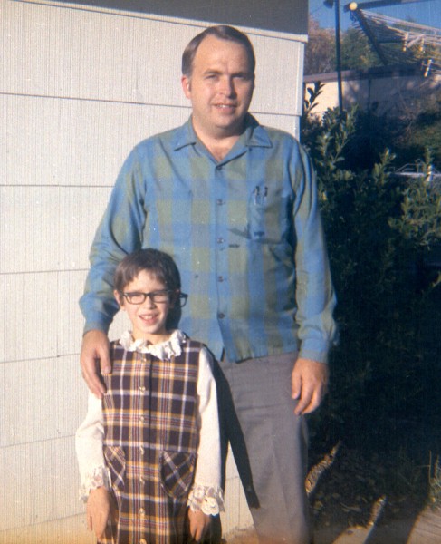 An adopted child poses for a picture with her adoptive father.  