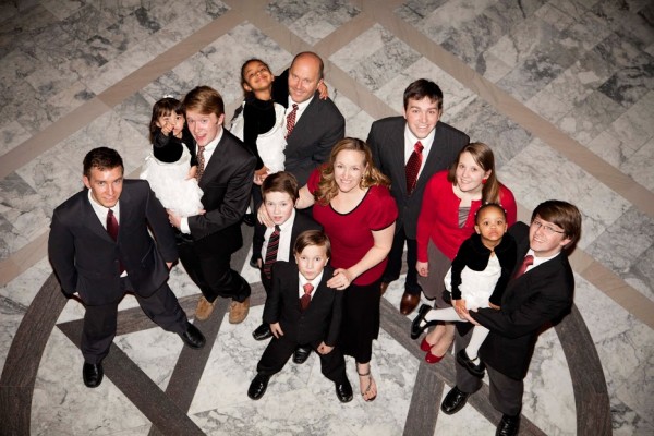 Bruce and Cindy Brewer with their six sons, one daughter-in-law, and three youngest adopted daughters, before adopting their last two daughters