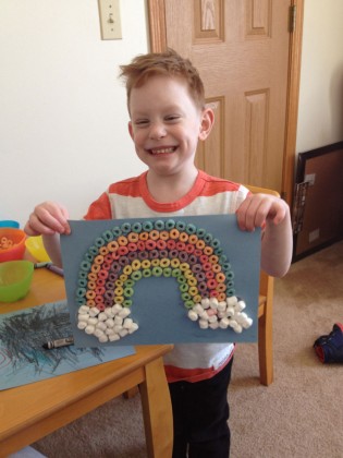 An adopted child shows off his craft from daycare.