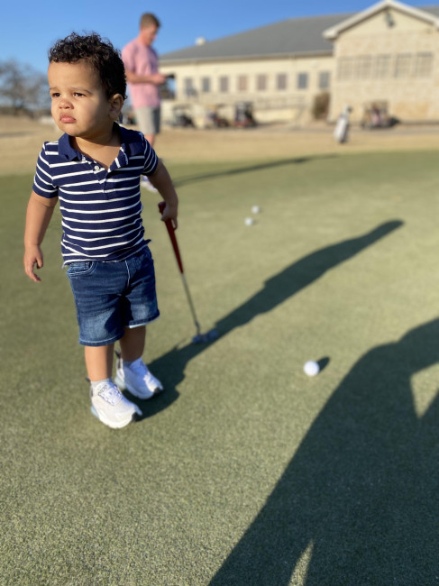 Noah loves to putt on the golf course with his grandpa. 