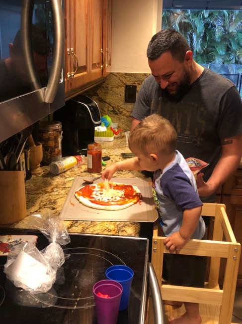 Calvin making a pizza with Jason.  Jason loves to cook and Chris and Calvin love eating everything he makes!