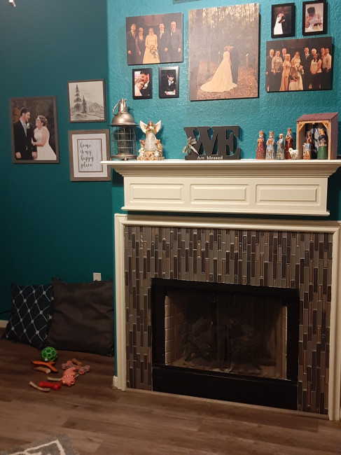 Our living room. Jeweled Teal Blue accent wall and a recently retiled fireplace. When we painted this It went onto the wall NEON BLUE. 