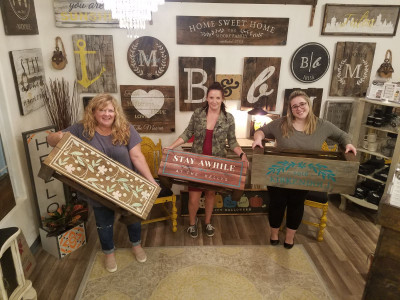 Monica with Jake's mom and Jake's brother's significant other with their finished handmade wooden projects