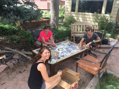 Brenda, her sister and mom making a mosaic table for our patio from old dishes.