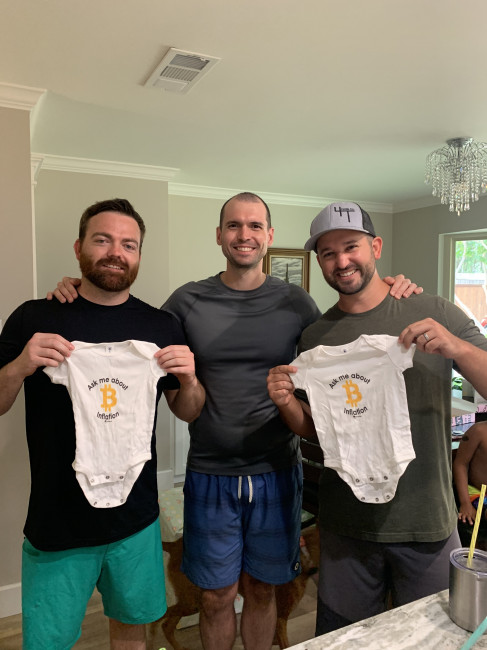 Matt posing with the dads-to-be holding onsies! 