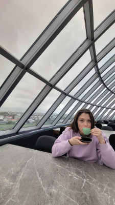 Molly drinking coffee at the Perlan Museum observation deck