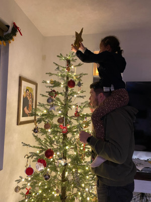 Dad always needs a little help putting the star on top of the tree.