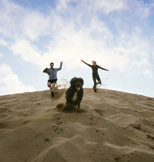 Having fun on beach sand dunes with our dog Zipper.